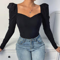 Style britannique à taille cintrée, décolleté plongeant et manches longues.